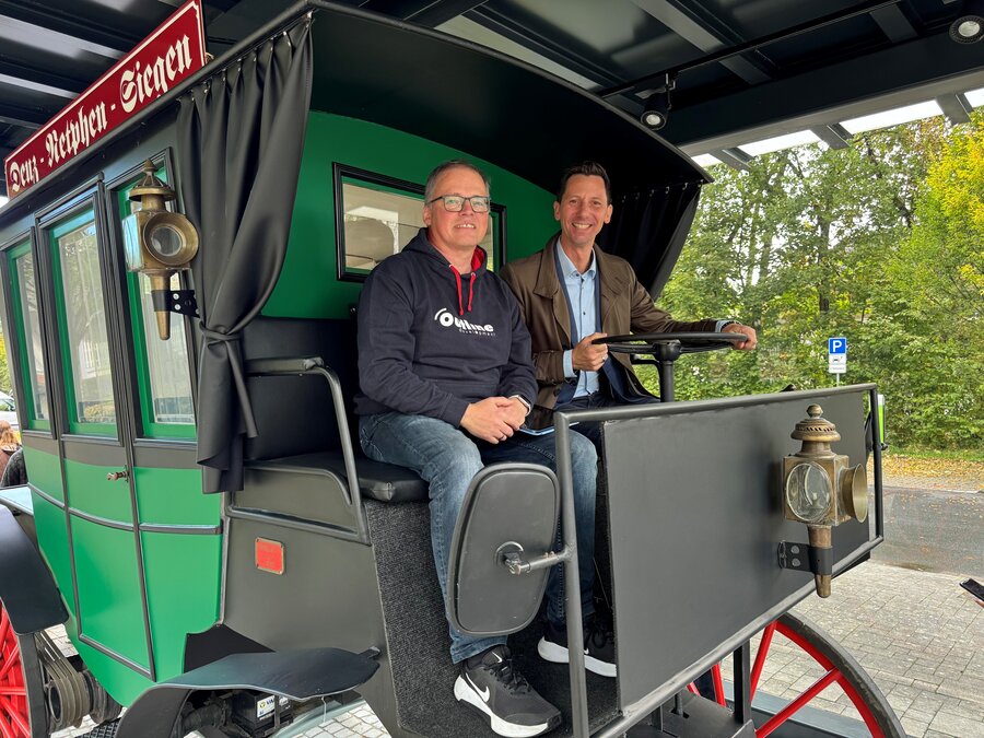 Landrat Andreas Müller und Spieleentwickler Tobias Müller auf dem Kutscherbock des Motoromnibus-Nachbaus